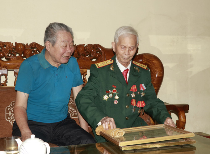 Những ký ức của ngày khói lửa nơi chiến trường miền Nam vẫn mãi là kỷ niệm hào hùng của cựu chiến binh Hà Hồng Việt (bên phải), ở tổ dân phố 5, thị trấn Yên Bình, huyện Yên Bình (Yên Bái). Ảnh: Tuấn Anh - TTXVN potal-50-nam-thong-nhat-dat-nuoc-ky-uc-hao-hung-ngay-thong-nhat-non-song-8006447.jpg