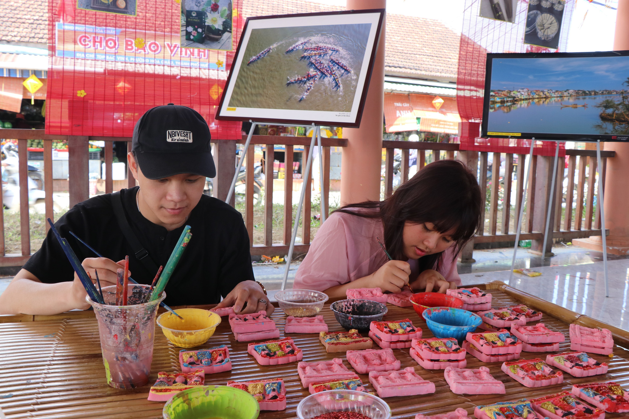 Du khách trải nghiệm làm tượng Tam vị táo quân - nghề truyền thống nổi tiếng tại tổ dân phố Địa Linh, phường Hóa Châu.