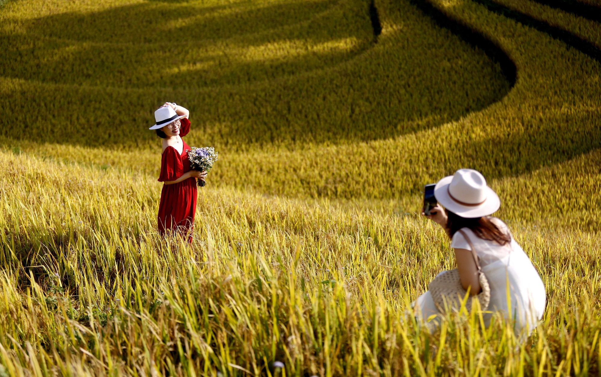 Du khách từ khắp nơi đổ về, háo hức ghi lại những khoảnh khắc đáng nhớ và đắm mình trong vẻ đẹp của mùa lúa chín. ruong-bac-thang10-011125.jpg