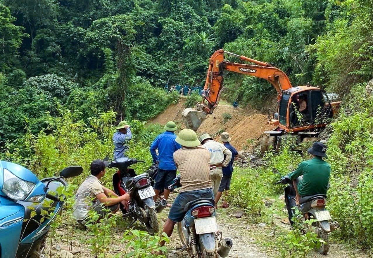 Máy ủi khẩn trương tham gia san gạt, giải phóng các điểm sạt lở hỗ trợ hành trình tiếp tế lương thực, thực phẩm, nhu yếu phẩm đến người dân bản Na Ngân được nhanh hơn. Ảnh: TTXVN phát na-ngan-121025.jpg