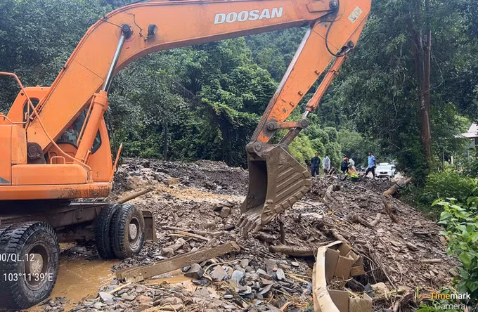 Các đơn vị tập trung phương tiện máy móc khắc phục hậu quả của mưa lũ gây ra tại km 81+100 trên Quốc lộ 12. Ảnh: TTXVN phát