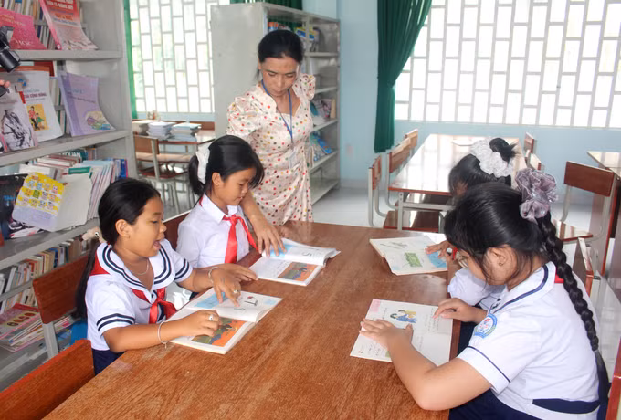 Học sinh tìm đọc thêm sách, ảnh tiếng Chăm tại thư viện Trường tiểu học Lâm Hưng, xã Hàm Thuận (tỉnh Lâm Đồng).