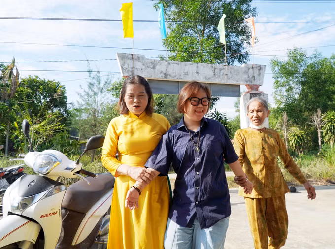 Thầy cô, người thân dìu các em khuyết tật vào dự lễ khai giảng.