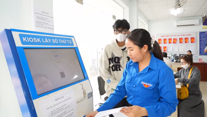 Đoàn viên Thanh niên phường Long Hoa, tỉnh Tây Ninh, hỗ trợ người dân đến thực hiện thủ tục đất đai tại UBDN phường.