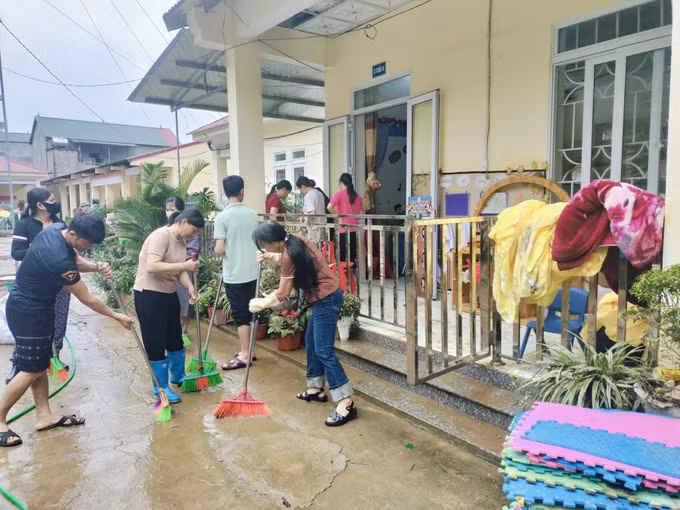 Người dân, lực lượng vũ trang tham gia khắc phục hậu quả sau mưa lớn tại Trường Mầm non và Tiểu học Minh Long. Ảnh: TTXVN phát