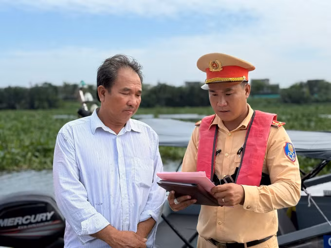 Lực lượng Cảnh sát đường thủy Long An kiểm tra chủ phương tiện vận chuyển khoáng sản trên sông Vàm Cỏ Đông. Ảnh: TTXVN phát
