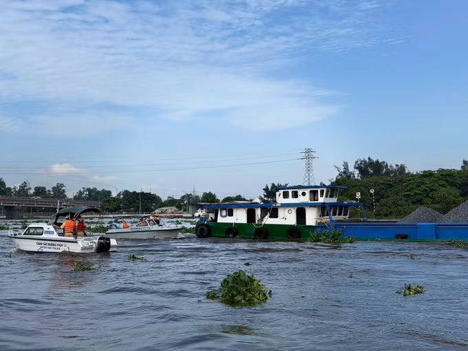 Lực lượng Cảnh sát đường thủy Long An kiểm tra chủ phương tiện vận chuyển khoáng sản trên sông Vàm Cỏ Đông. Ảnh: TTXVN phát