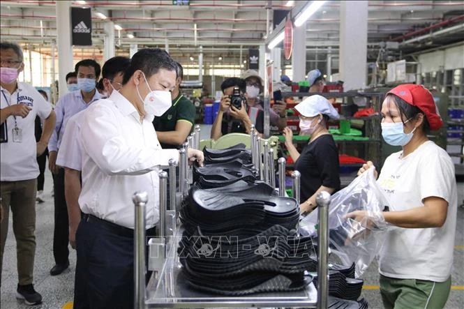 Phó Chủ tịch Dương Anh Đức thăm hỏi công nhân tại các chuyền sản xuất của Công ty trách nhiệm hữu hạn Pouyuen Việt Nam (quận Bình Tân). Ảnh: Thanh Vũ - TTXVN