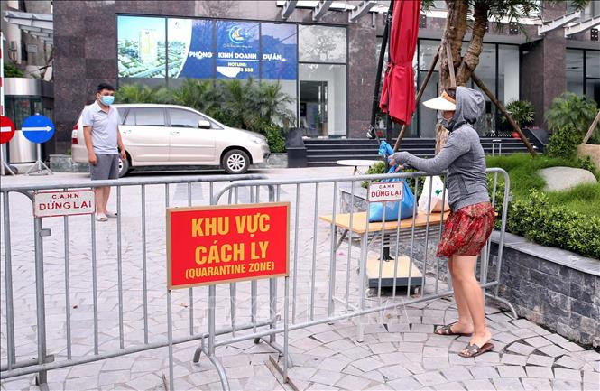 Người thân đưa đồ nhu yếu phẩm thiết yếu tiếp tế cho cư dân sống tại Toà chung cư Viễn Đông Star (số 1 phố Giáp Nhị, quận Hoàng Mai, Hà Nội) bị phong tỏa. Ảnh: Phạm Kiên - TTXVN