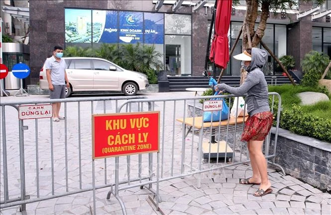Người thân đưa đồ nhu yếu phẩm thiết yếu tiếp tế cho cư dân sống tại Toà chung cư Viễn Đông Star (số 1 phố Giáp Nhị, quận Hoàng Mai, Hà Nội) bị phong tỏa. Ảnh: Phạm Kiên - TTXVN