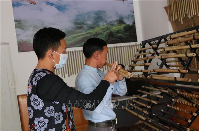 Anh Ma A Cháng, ở bản Sin Câu, xã Giang Ma, huyện Tam Đường hướng dẫn khách hàng thổi sáo. Ảnh: Việt Hoàng - TTXVN 