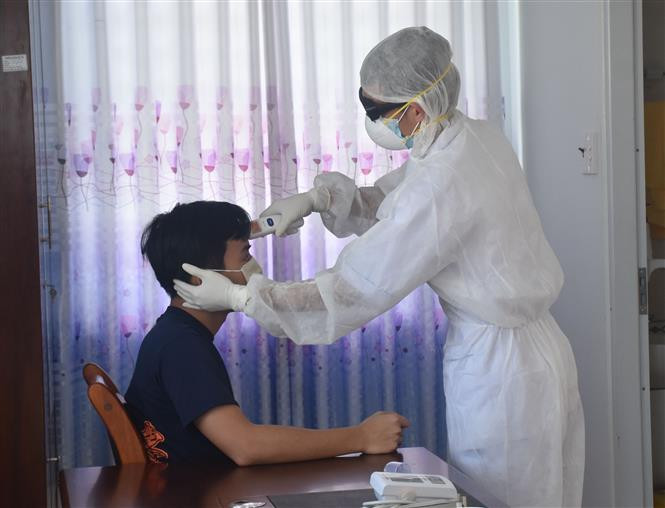 Kiểm tra tình hình sức khỏe cho người cách ly tại khu cách ly tập trung. Ảnh: Hoàng Nhị - TTXVN