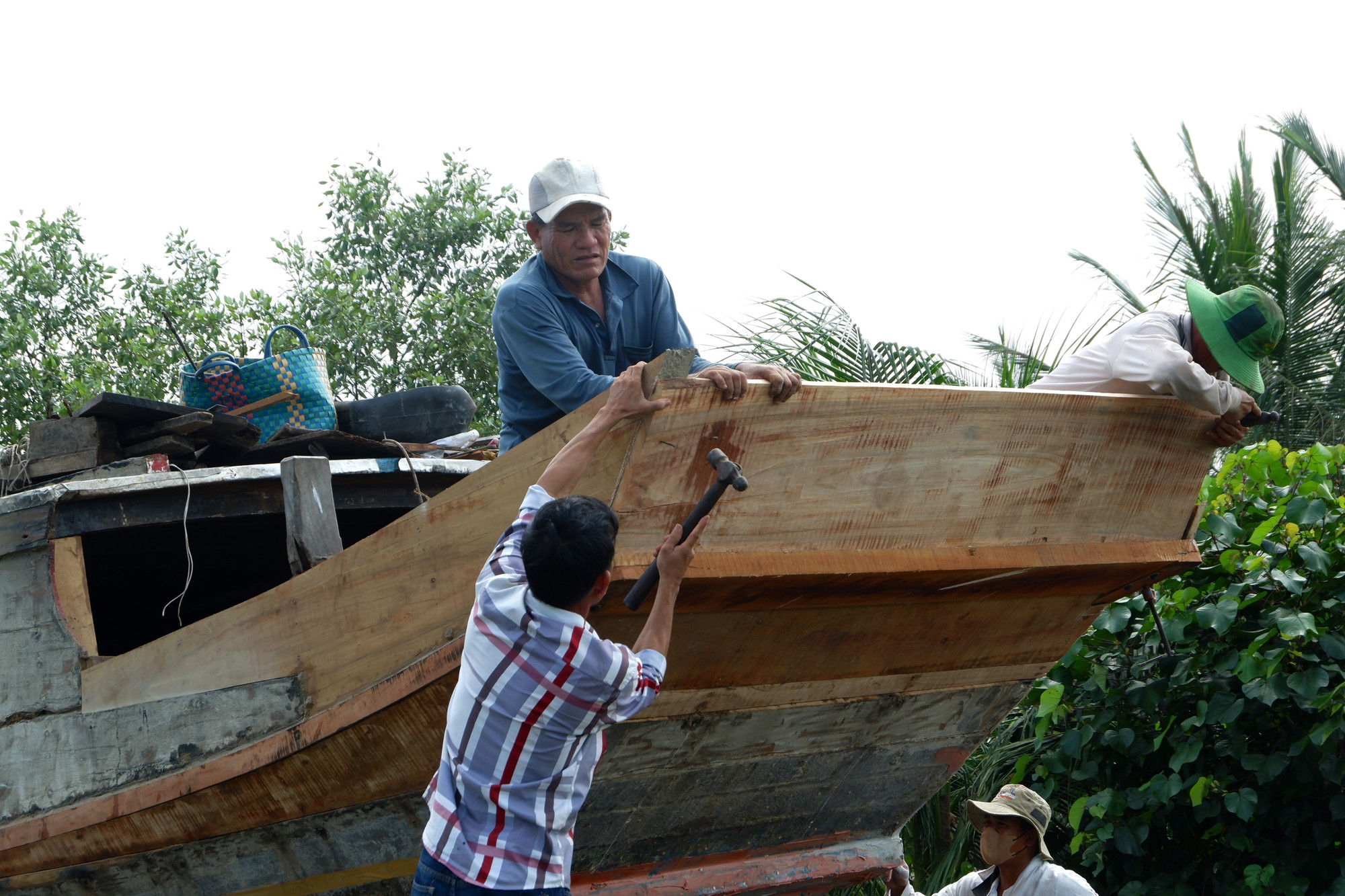 Những người thợ làng đóng ghe xã Đông Thạnh, huyện Cần Giuộc xưa sửa chữa ghe. Ảnh: Đức Hạnh/TTXVN dong-ghe-26725-15.jpg