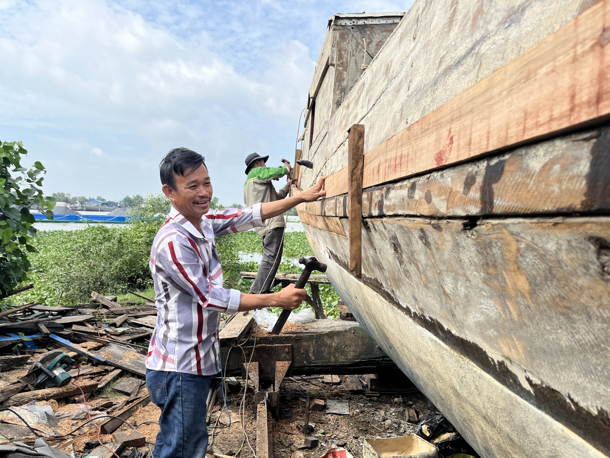 Ông Huỳnh Văn Hiệu là chủ cơ sở đóng ghe, xuồng gỗ duy nhất còn lại của làng nghề truyền thống đóng ghe xuồng xã Đông Thạnh, huyện Cần Giuộc (tỉnh Long An cũ). Ảnh: Đức Hạnh/TTXVN dong-ghe-26725-14.jpg