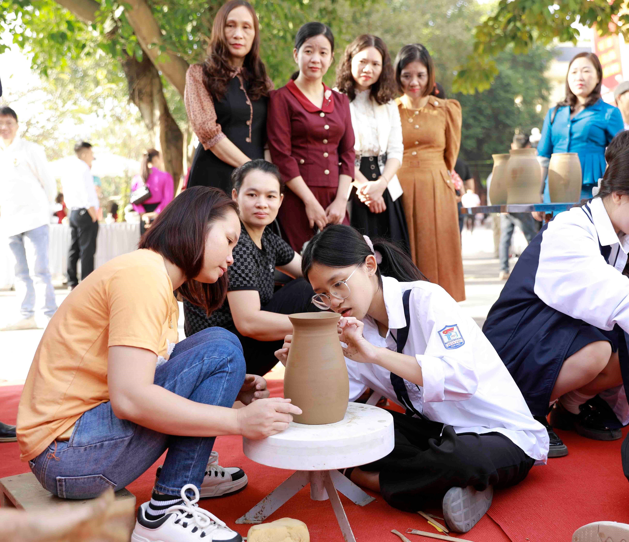 Học sinh Vĩnh Phúc trải nghiệm kĩ thuật nặn gốm cùng các nghệ nhân của Làng nghề gốm Hương Canh, huyện Bình Xuyên. Ảnh: Hoàng Hùng/TTXVN gom-huong-canh-25525-11.jpg
