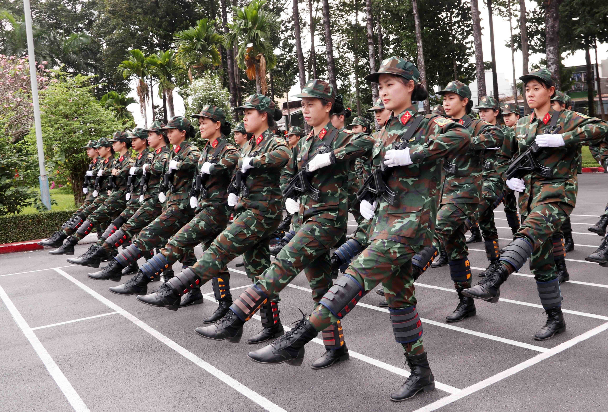 Đội A50 Nữ Chiến sĩ Biệt động Sài Gòn luyện tập ke chân với tạ để tăng sức bền và rèn thể lực. Ảnh: Xuân Khu-TTXVN potal-50-nam-thong-nhat-dat-nuoc-nhung-bong-hong-doi-nang-thang-mua-luyen-tap-cho-le-duyet-binh-7889054.jpg