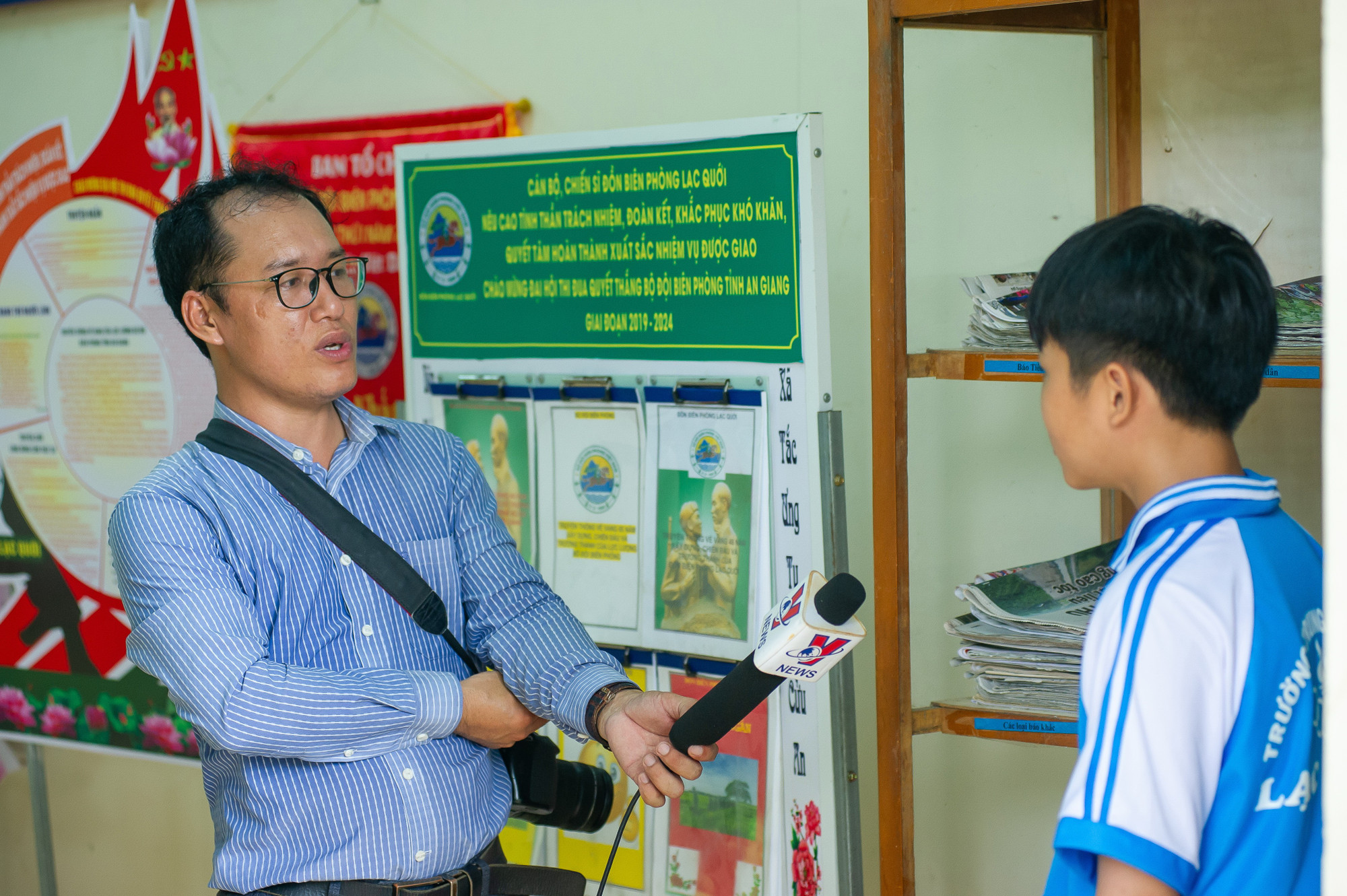 Nhà báo Đặng Công Mạo, Phóng viên TTXVN thường trú tại tỉnh An Giang phỏng vấn cháu Nguyễn Văn Duy Chương, 11 tuổi mồ côi cả cha lẫn mẹ, ngày ngày vẫn trong vòng tay che chở của “những người cha quân hàm xanh" của Đồn Biên phòng Lạc Quới, huyện Tri Tôn (An Giang). Ảnh: An Hiếu chuyendein-23a.jpg