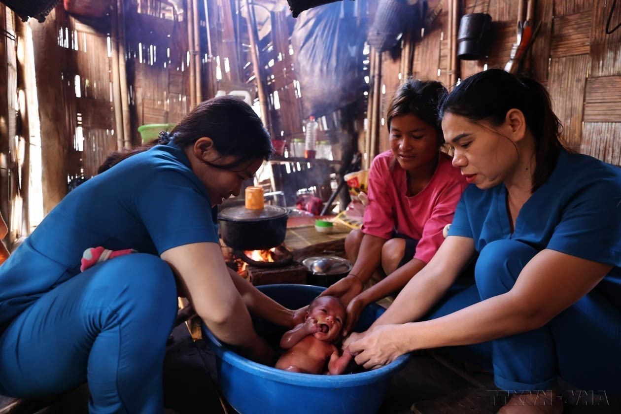 Bác sĩ Hồ Thị Vy (phải) có 9 năm công tác tại Trạm y tế xã Hướng Lập, huyện Hướng Hóa (Quảng Trị) đang hướng dẫn cách chăm sóc trẻ sơ sinh tại nhà cho bà con dân tộc. Ảnh: Minh Đức – TTXVN potal-70-nam-ngay-thay-thuoc-viet-nam-27021955-27022025-y-te-co-so-xuong-song-cua-he-thong-y-te-viet-nam-7852612.jpg