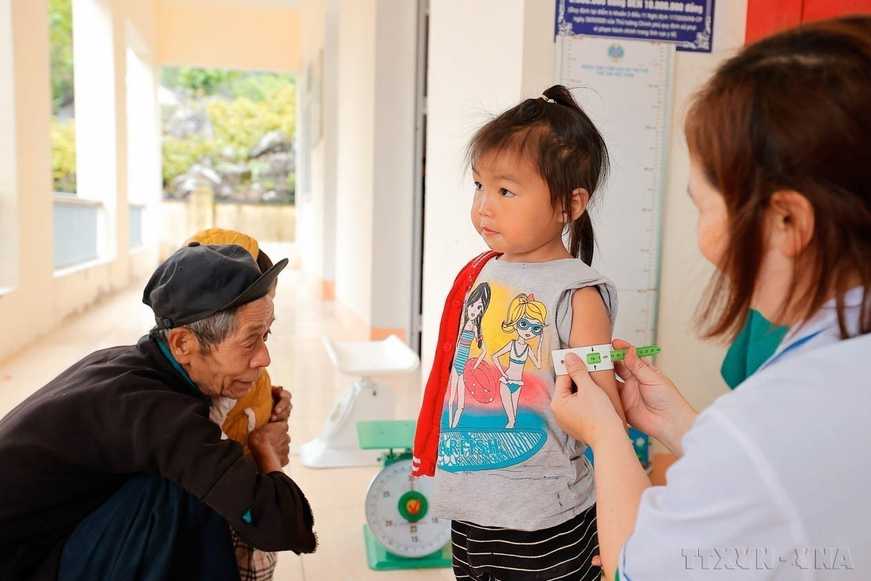 Trạm y tế xã Giàng Chu Phìn (huyện Mèo Vạc, tỉnh Hà Giang) tổ chức cân, đo cho trẻ định kỳ 6 tháng 1 lần nhằm đánh giá tỷ lệ suy dinh dưỡng của trẻ nhỏ trên địa bàn xã. Ảnh: Minh Quyết – TTXVN potal-70-nam-ngay-thay-thuoc-viet-nam-27021955-27022025-y-te-co-so-xuong-song-cua-he-thong-y-te-viet-nam-7852694.jpg