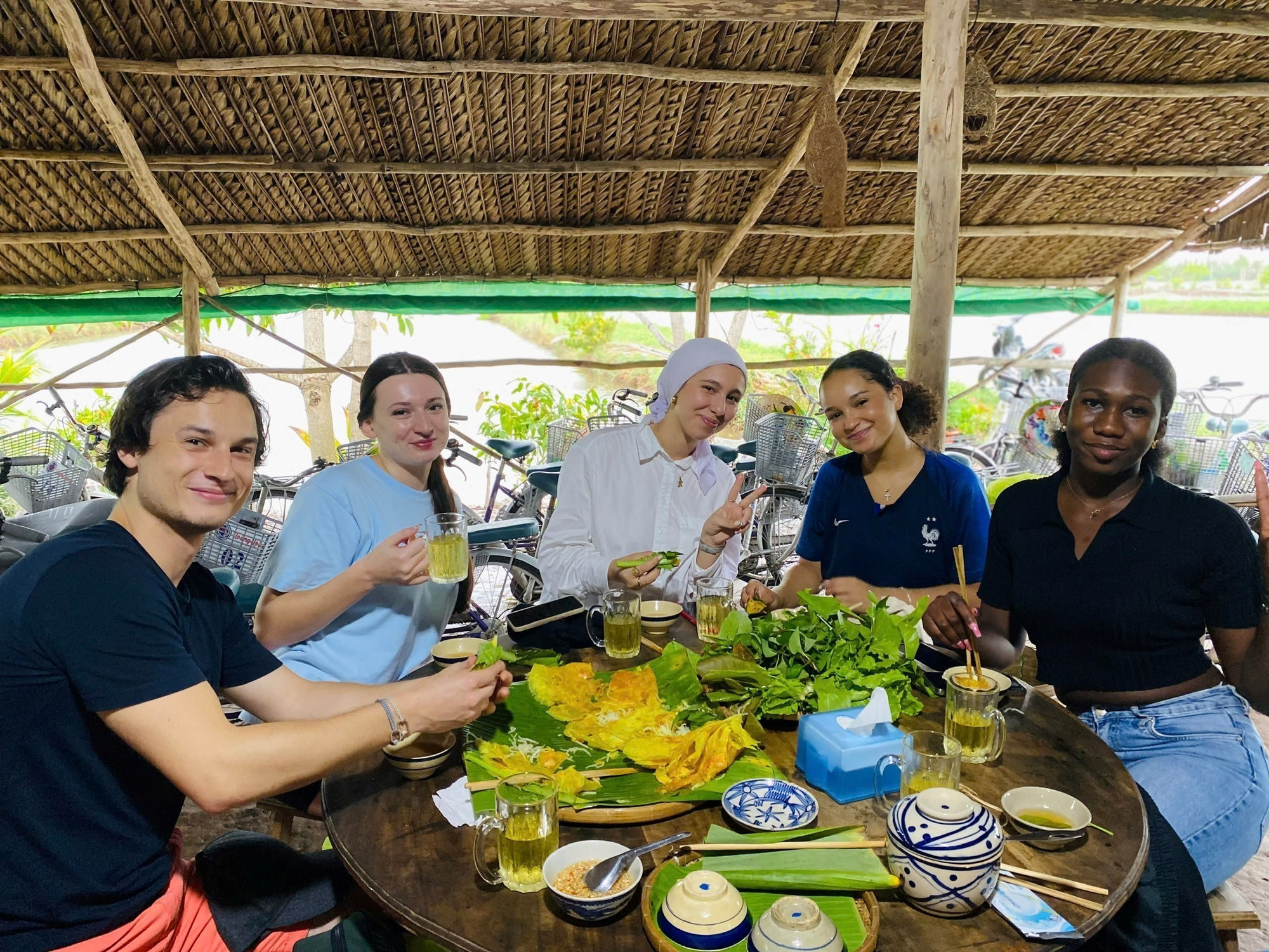 Du khách nước ngoài thưởng thức ẩm thực địa phương tại Cồn Chim. Ảnh: TTXVN phát potal-diem-du-lich-cong-dong-con-chim-tra-vinh-nhan-giai-thuong-du-lich-asean-2025-7823443.jpg