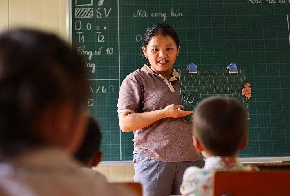 Giáo viên, đảng viên trẻ Sùng Thị Say trong một buổi dạy chữ cho học sinh lớp 1 chuẩn bị bước vào năm học mới. Ảnh: Minh Đức – TTXVN sung-say-05.jpg