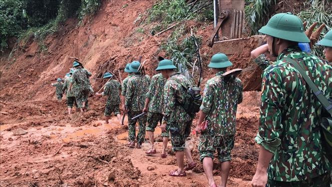 Lực lượng cứu hộ, cứu nạn hành quân tới hiện trường vụ sạt lở trong điều kiện vô cùng khó khăn do đường giao thông có nhiều điểm bị sạt lở nghiêm trọng. Ảnh: Thanh Thủy - TTXVN