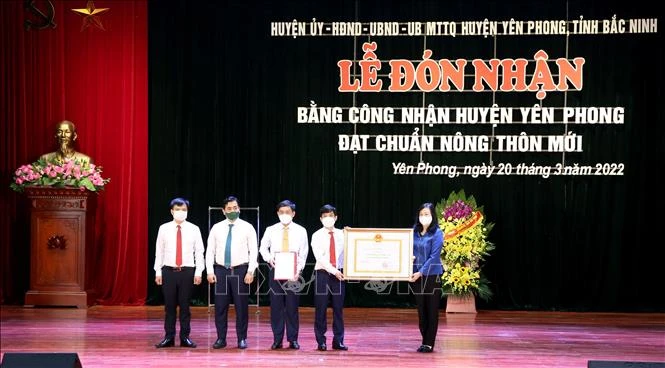 Bí thư Tỉnh ủy Bắc Ninh Đào Hồng Lan trao Bằng công nhận đạt chuẩn Nông thôn mới cho Đảng bộ, chính quyền và nhân dân huyện Yên Phong. Ảnh: Đinh Văn Nhiều-TTXVN