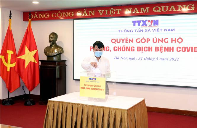 Tổng Giám đốc TTXVN Nguyễn Đức Lợi quyên góp, ủng hộ Quỹ phòng, chống dịch COVID-19. Ảnh: Phạm Kiên - TTXVN