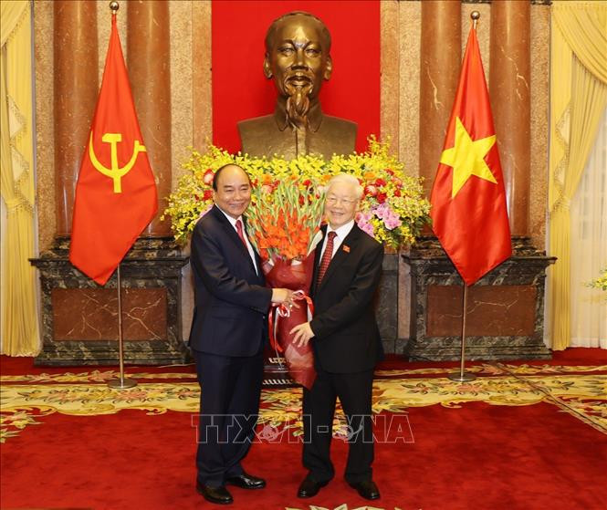Chủ tịch nước Nguyễn Xuân Phúc tặng hoa Tổng Bí thư Nguyễn Phú Trọng, nguyên Chủ tịch nước. Ảnh: Trí Dũng – TTXVN