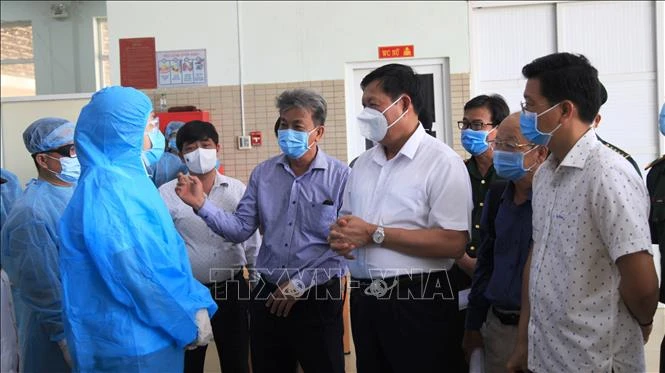 Thứ trưởng Bộ Y tế Đỗ Xuân Tuyên (áo trắng) trao đổi với lực lượng kiểm soát y tế tại Cửa khẩu quốc tế Mộc Bài, huyện Bến Cầu, tỉnh Tây Ninh. Ảnh: Thanh Tân - TTXVN