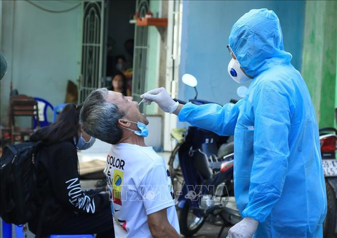 Nhân viên y tế lấy mẫu xét nghiệm người dân trong khu vực Lô E, Lò Gốm (Phường 7, Quận 6). Ảnh: Đinh Hằng - TTXVN