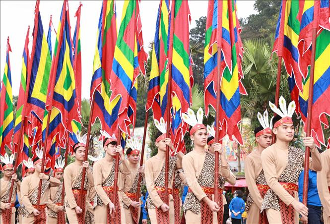 100 thanh niên tượng trưng cho con Lạc, cháu Hồng trong trang phục cổ, tay giương cao cờ hội, thể hiện sức sống mãnh liệt của dòng giống Tiên Rồng. Ảnh: Thống Nhất – TTXVN
