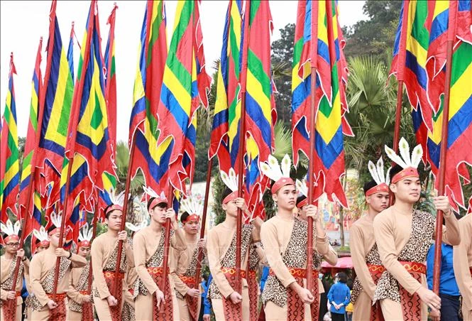 100 thanh niên tượng trưng cho con Lạc, cháu Hồng trong trang phục cổ, tay giương cao cờ hội, thể hiện sức sống mãnh liệt của dòng giống Tiên Rồng. Ảnh: Thống Nhất – TTXVN