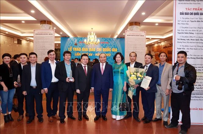 Chủ tịch nước Nguyễn Xuân Phúc, Tổng biên tập báo Nhân Dân Lê Quốc Minh và Tổng giám đốc TTXVN Vũ Việt Trang cùng các nhà báo của TTXVN. Ảnh: Thống Nhất – TTXVN