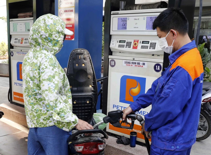 Mua bán xăng, dầu tại một điểm kinh doanh xăng dầu Petrolimex. Ảnh: Trần Việt - TTXVN