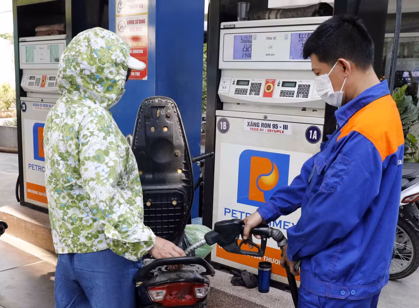 Mua bán xăng, dầu tại một điểm kinh doanh xăng dầu Petrolimex. Ảnh: Trần Việt - TTXVN