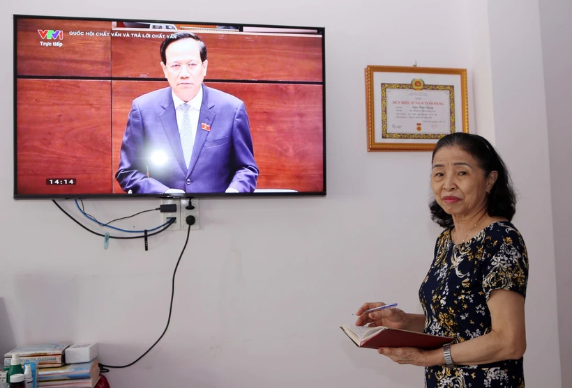 Cử tri là đảng viên Lê Thị Đào Liễu (quận Hải Châu, thành phố Đà Nẵng) theo dõi phiên chất vấn và trả lời chất vấn tại Kỳ họp thứ 5, Quốc hội khóa XV vào chiều 6/6. Ảnh: Trần Lê Lâm - TTXVN