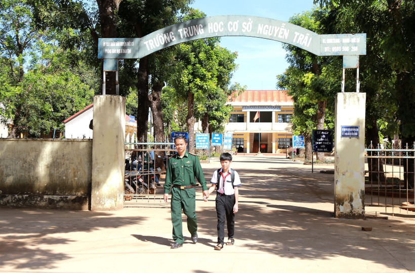 Bố nuôi tận tâm đón các em về sau mỗi giờ học. Ảnh: Quang Thái- TTXVN