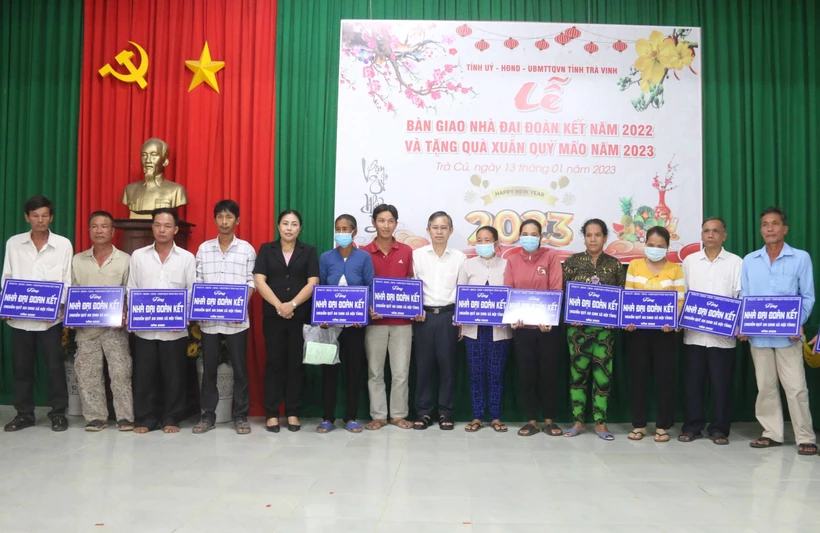 Trao bảng tượng trưng bàn giao nhà đại đoàn kết cho hộ nghèo. Ảnh: Thanh Hòa - TTXVN