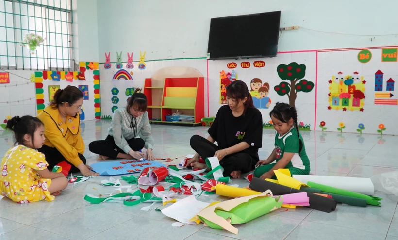 Các cô giáo Trường Mẫu giáo xã Mong Thọ A, huyện Châu Thành (Kiên Giang) làm đồ trang trí lớp học. Ảnh: Văn Sĩ - TTXVN
