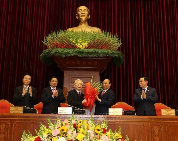 hay mặt Bộ Chính trị khóa XIII, đồng chí Nguyễn Xuân Phúc, Thủ tướng Chính phủ tặng hoa chúc mừng đồng chí Nguyễn Phú Trọng được tín nhiệm bầu làm Tổng Bí thư Ban Chấp hành Trung ương Đảng Cộng sản Việt Nam khóa XIII. Ảnh: Trí Dũng –TTXVN