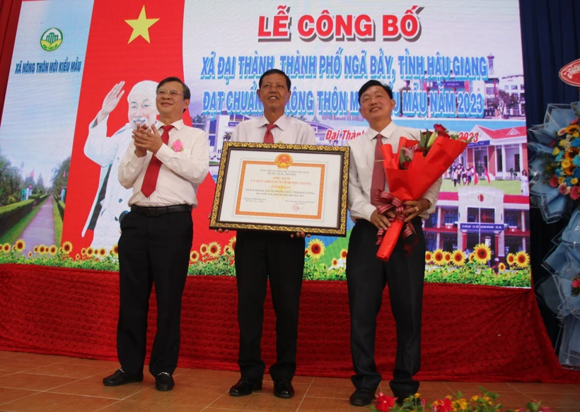 Lãnh đạo tỉnh Hậu Giang trao bảng công nhận xã Đại Thành, thành phố Ngã Bảy đạt chuẩn nông thôn mới kiểu mẫu. Ảnh: Nguyễn Hằng - TTXVN