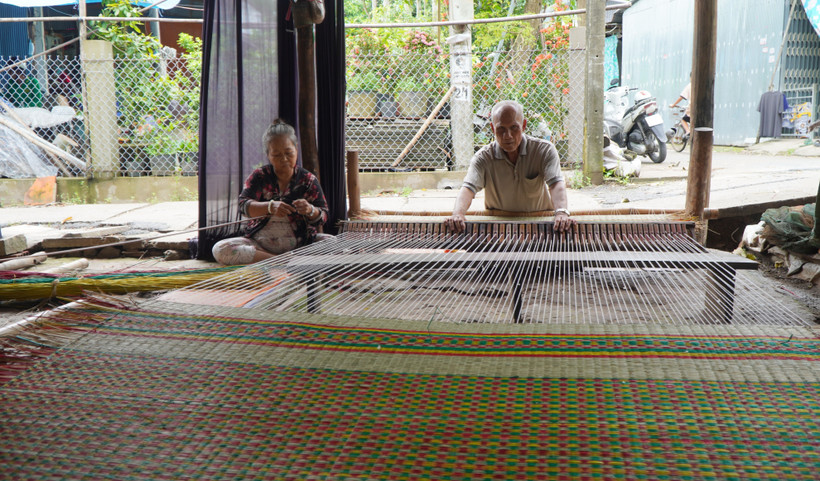 Gia đình ông Huỳnh Văn Chiến là một trong số ít hộ dân ở làng chiếu Định Yên còn dệt chiếu thủ công để giới thiệu nghề truyền thống với khách du lịch. Ảnh: Nhựt An - TTXVN