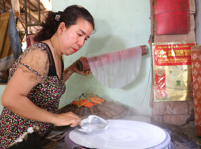 Chị Trần Thị Thanh Tuyền (xã Lục Sỹ Thành, tỉnh Vĩnh Long) là thế hệ thứ ba trong gia đình giữ nghề làm bánh tráng truyền thống. Ảnh: Lê Thúy Hằng/TTXVN
