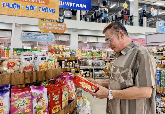 Ông Tạ Minh Sơn, Giám đốc Siêu thị Tứ Sơn kiểm tra các sản phẩm đặc sản vùng miền được trưng bày tại Trung tâm nông nghiệp và đặc sản Việt Nam ở An Giang.