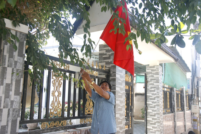 Người dân ở làng Chăm Bình Đức treo cờ Tổ quốc hướng về Ngày hội non sông.