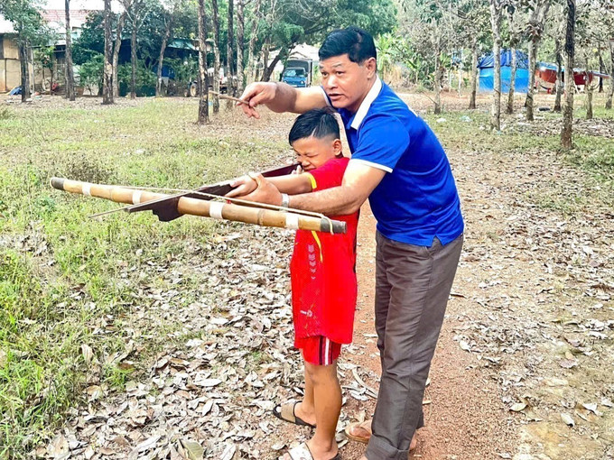 Anh Bùi Văn Miệt hướng dẫn con môn thể thao truyền thống.