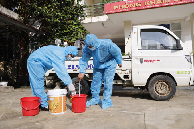 Cán bộ Trung tâm kiểm soát bệnh tật tỉnh Lào Cai pha Cloramin B phun khử khuẩn môi trường. Ảnh: Tuấn Anh/TTXVN ve-sinh-moi-truong-lao-cai-2934.jpg