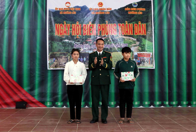 Đại diện Ban Chỉ huy Bộ đội Biên phòng tỉnh Sơn La trao quà cho 2 học sinh thuộc Chương trình “Nâng bước em tới trường, con nuôi Đồn Biên phòng”.