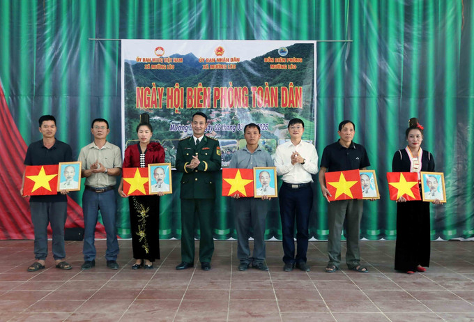 Tặng cờ Tổ quốc và ảnh Bác Hồ cho các đại diện các bản thuộc xã Mường Lèo.